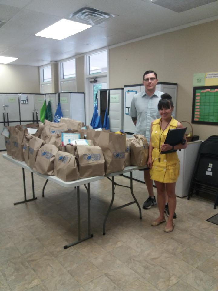 Members of the TCA Austin team pose with shopping carts full of donations collected for charity. 